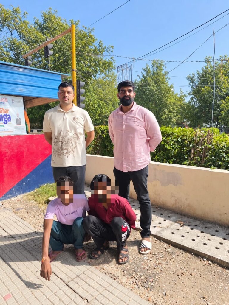 Police personnel with two apprehended men whose faces are pixelated in the supplied photograph