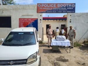 Delhi Police Recover 14.774 Kg More Ganja in Narela Case; Two Held Police personnel, two face-covered men, packages and a car outside a Narela Industrial Area police booth in a Delhi Police photograph.