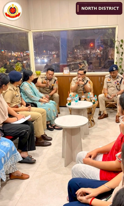 Women students seated with police officers during the DU North Campus Pink Booth interaction