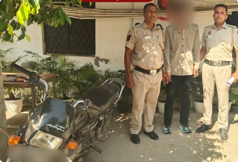 Nihal Vihar Police Recover Stolen Motorcycle After Arrest Nihal Vihar police personnel with the arrested accused and recovered motorcycle; face and registration plate blurred in the source image.
