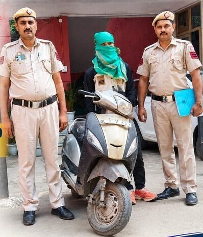 Police personnel with a masked accused and a scooty in the Jafrabad recovery photograph