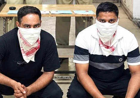Two masked accused in a North-East Delhi Police photograph