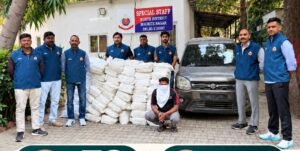 Police personnel and a masked accused beside the recovered consignment and a WagonR in the North District police photograph