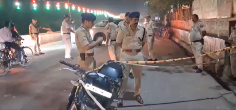 Police personnel and a motorcycle behind a cordon at the Sonia Vihar scene, cropped from the editor-provided video screenshot