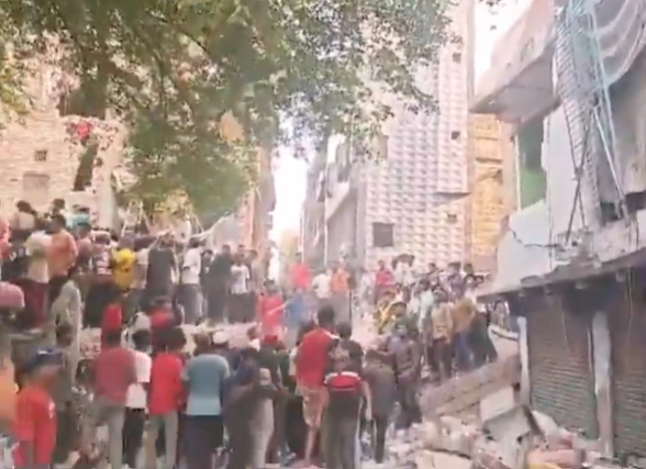 People and debris at the site of the Seemapuri building collapse in Delhi