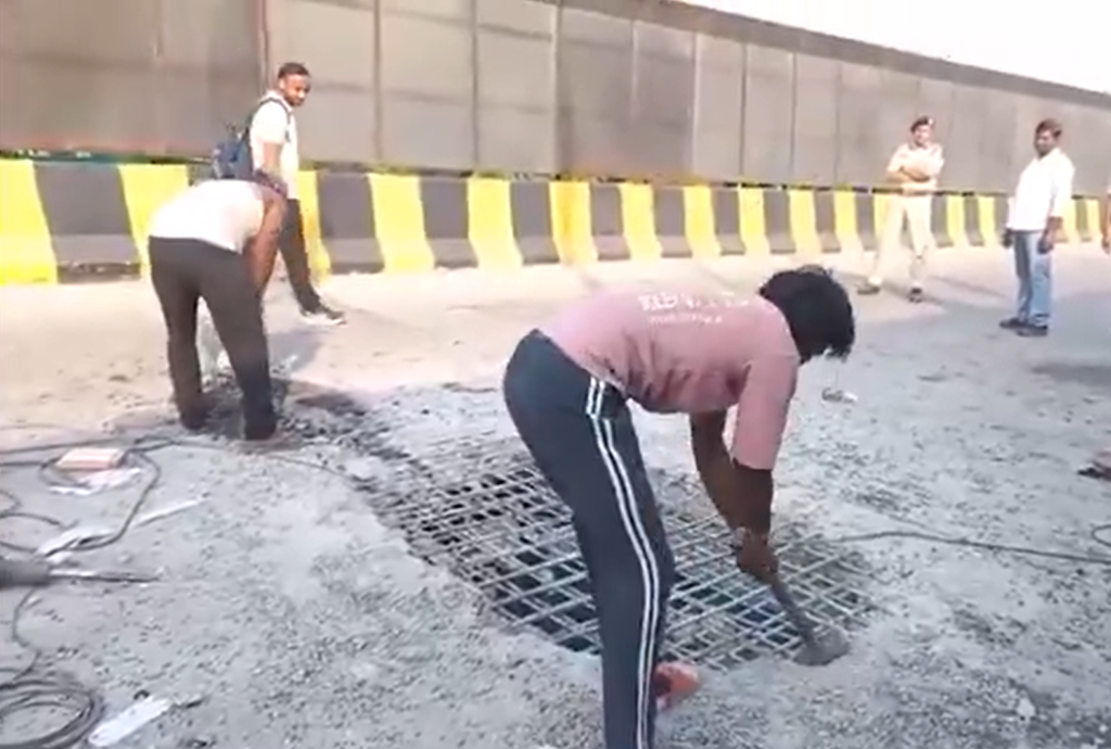 Workers repairing a damaged road surface on the Old RTR Flyover in Delhi