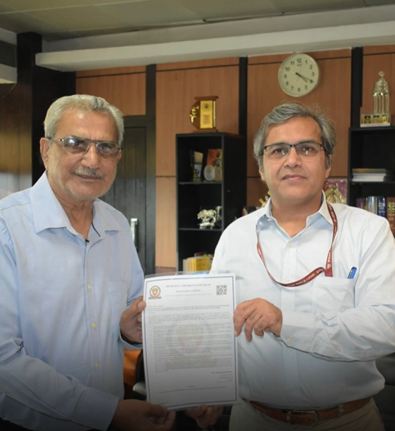 Two men standing together and holding a document in an office.