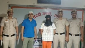 Tis Hazari Robbery: One Arrested, ₹15.90 Lakh Recovered Police personnel stand with two men in a briefing room, one wearing a black face covering.