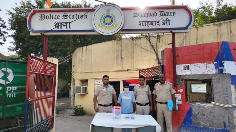 Shahbad Dairy Arms Arrest Leads Police to Robbery Case; Cash, ID Documents Recovered Police officers with a masked accused and recovered articles outside Shahbad Dairy police station
