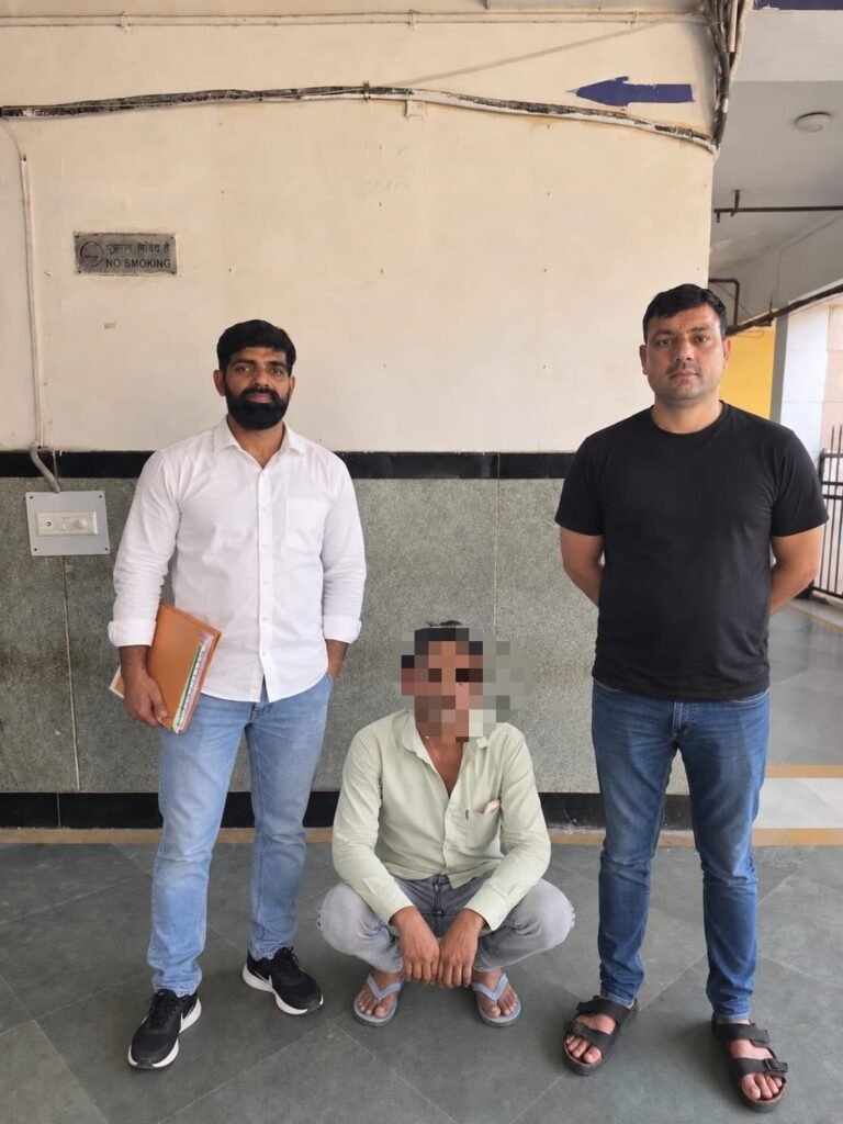 Delhi Police personnel with the apprehended man, whose face is pixelated in the supplied photograph