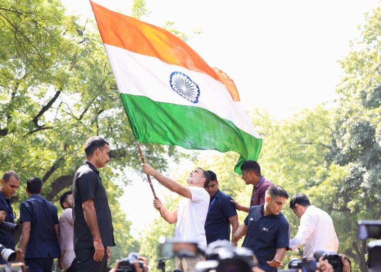 Rahul Gandhi holds the Indian national flag outdoors