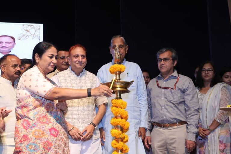 Chief Minister Rekha Gupta lights a ceremonial lamp at the MCD public-health staff programme at Civic Centre, with other officials present.