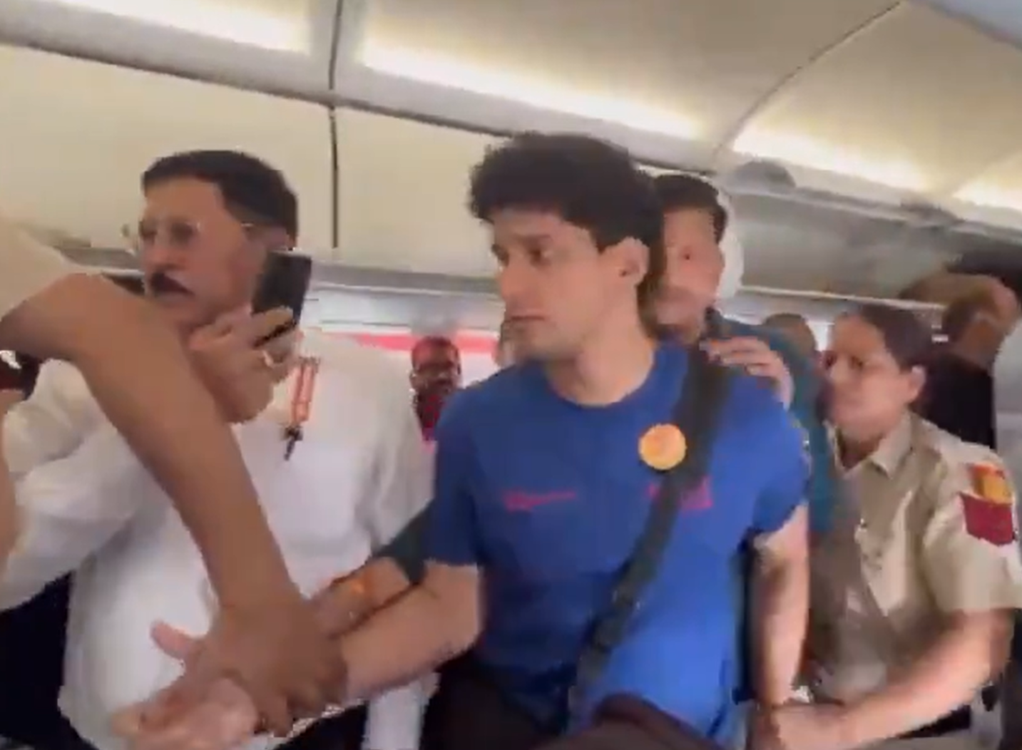 A man in a blue shirt beside a woman police officer in the cabin