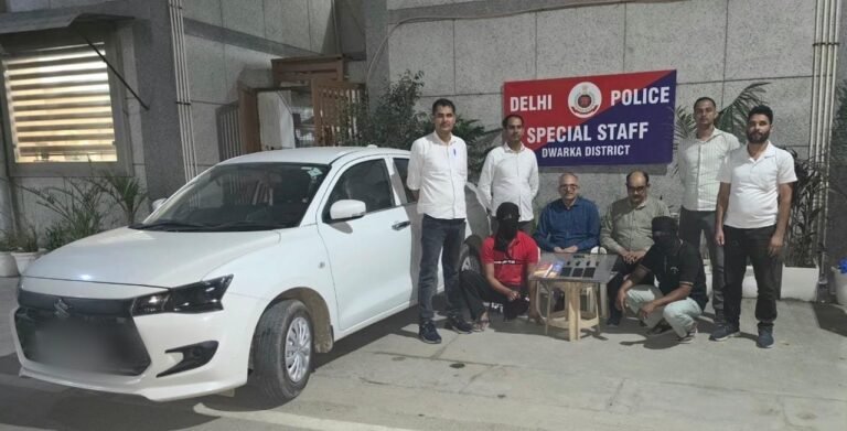 Two accused with seized items and a white car outside the Dwarka Special Staff office