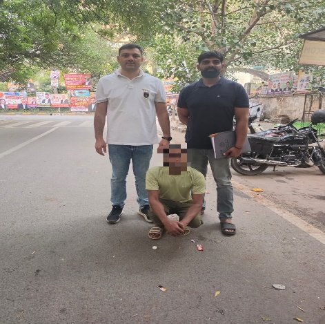Police personnel with one of the men apprehended in the proclaimed-offender operation. The face is obscured in the supplied photograph
