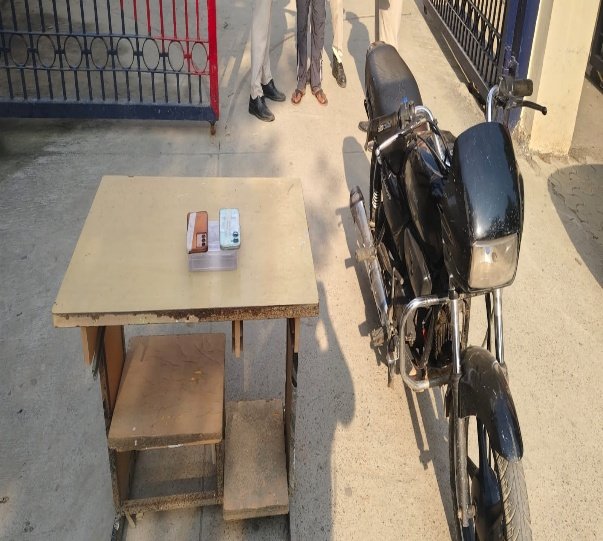 Two mobile phones on a table beside the motorcycle reported recovered in the Bawana snatching investigation