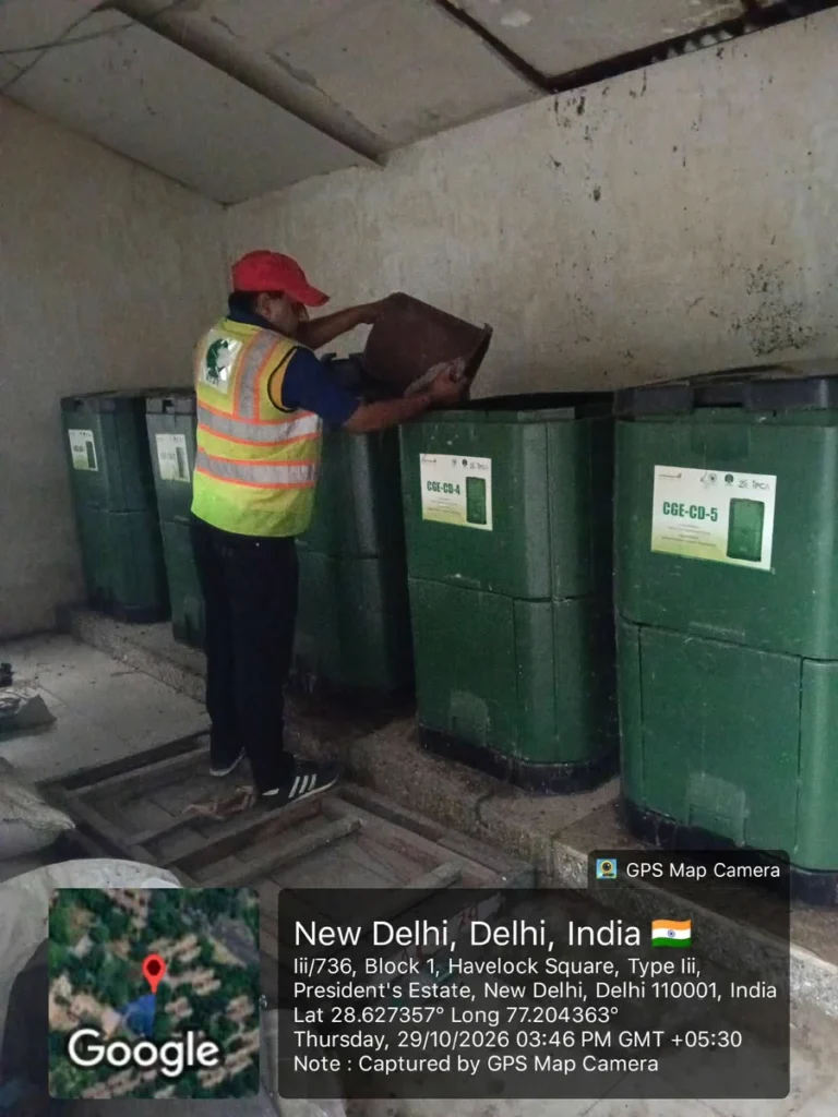 A sanitation worker handles a container beside green bins in NDMC’s waste segregation drive photograph