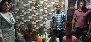 Police personnel with face-blurred individuals in the North-West district gambling case photograph